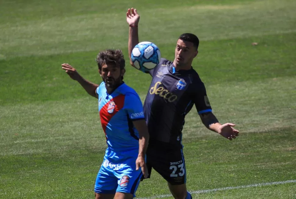 APORTA EN ATAQUE. Carrera presiona a Papa en la recepción de la pelota. El volante “decano” propuso en el área rival y complicó pese a no ser su mejor partido. 