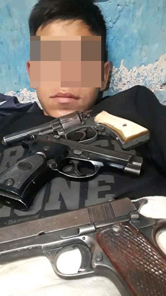 MÁS ARMAS. “Pequeño” posando con tres pistolas sobre su pecho.