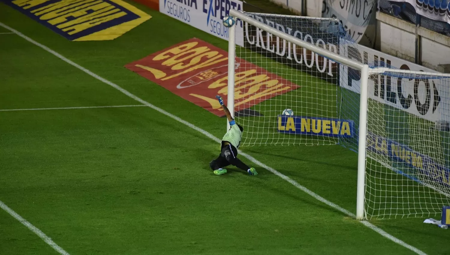 TREMENDO. Lucchetti se volcó a la derecha para desviar el fuerte remate del jugador de Racing-