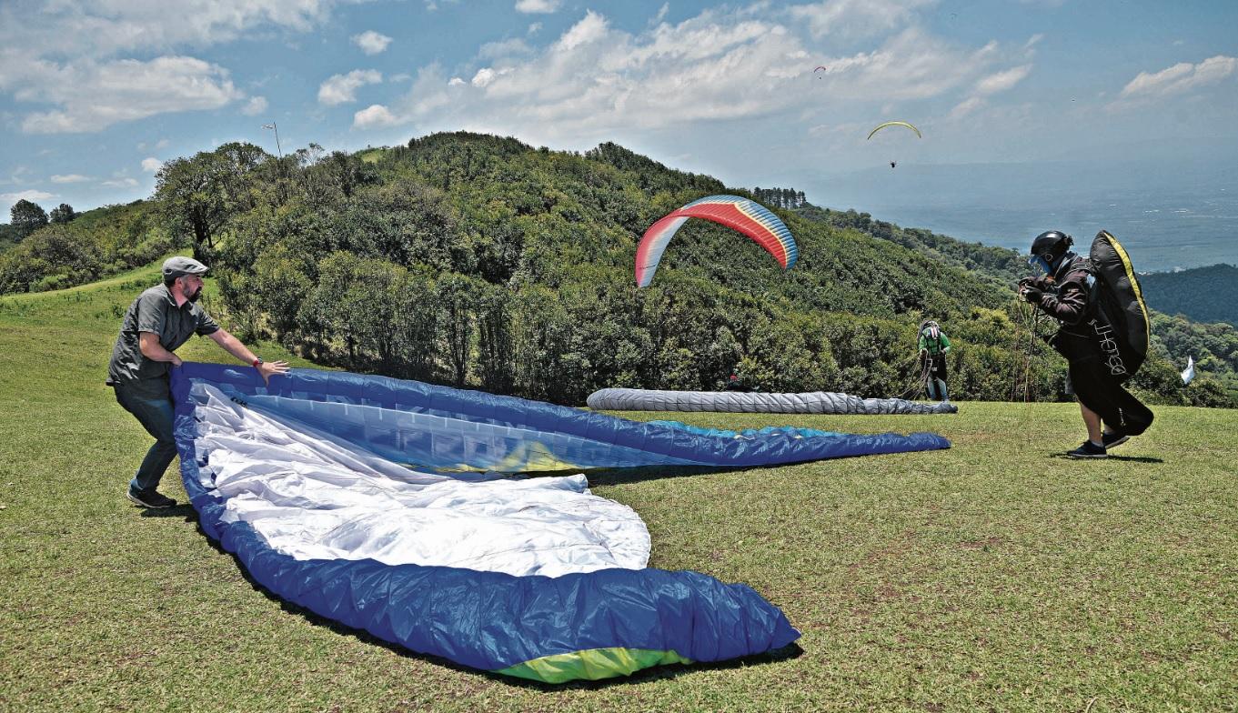 A PURO COLOR. Los parapentes tienen diversos diseños y sus telas muestran vistosos colores, que permiten seguirlos en pleno vuelo y distinguirlos cuando llegan al suelo. La labor de despliegue y repliegue es parte de la actividad.