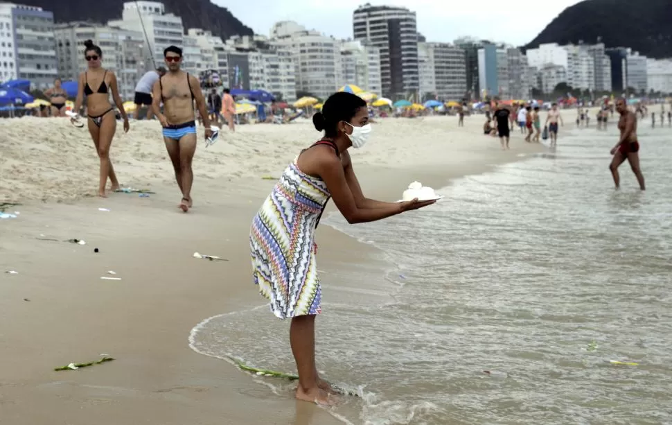 COPACABANA. Una religiosa afrobrasilera rinde homenaje a la diosa del mar, Yemanja, durante la celebración de Año Nuevo, en Río de Janeiro, Brasil. 