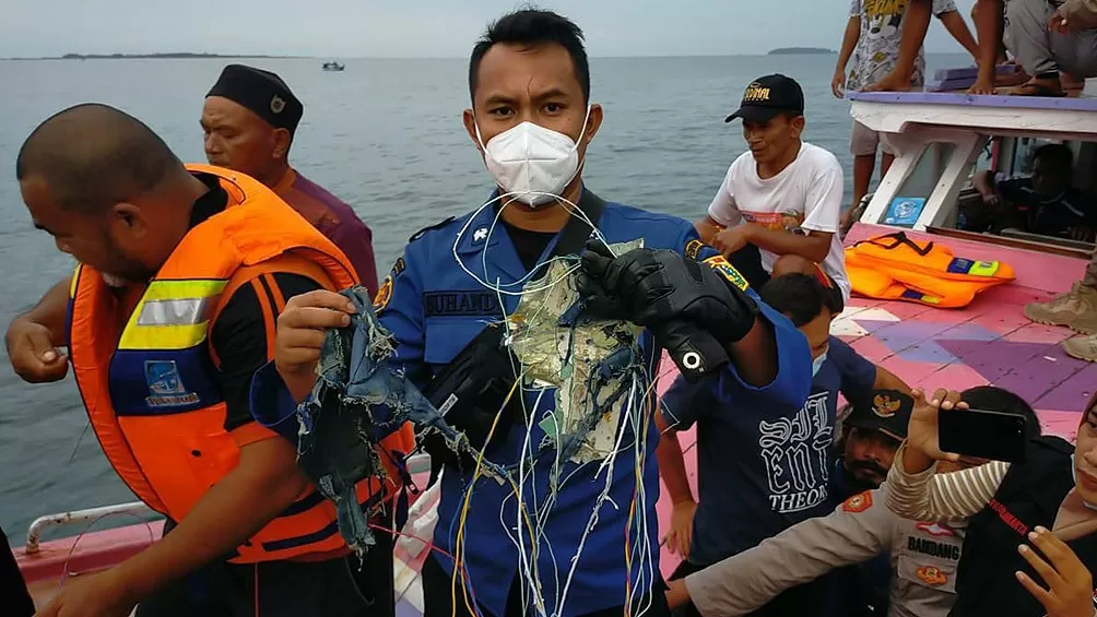 LOS BUZOS TRABAJAN PARA RESCATAR LOS RESTOS DEL AVIÓN. FOTO TELAM. 