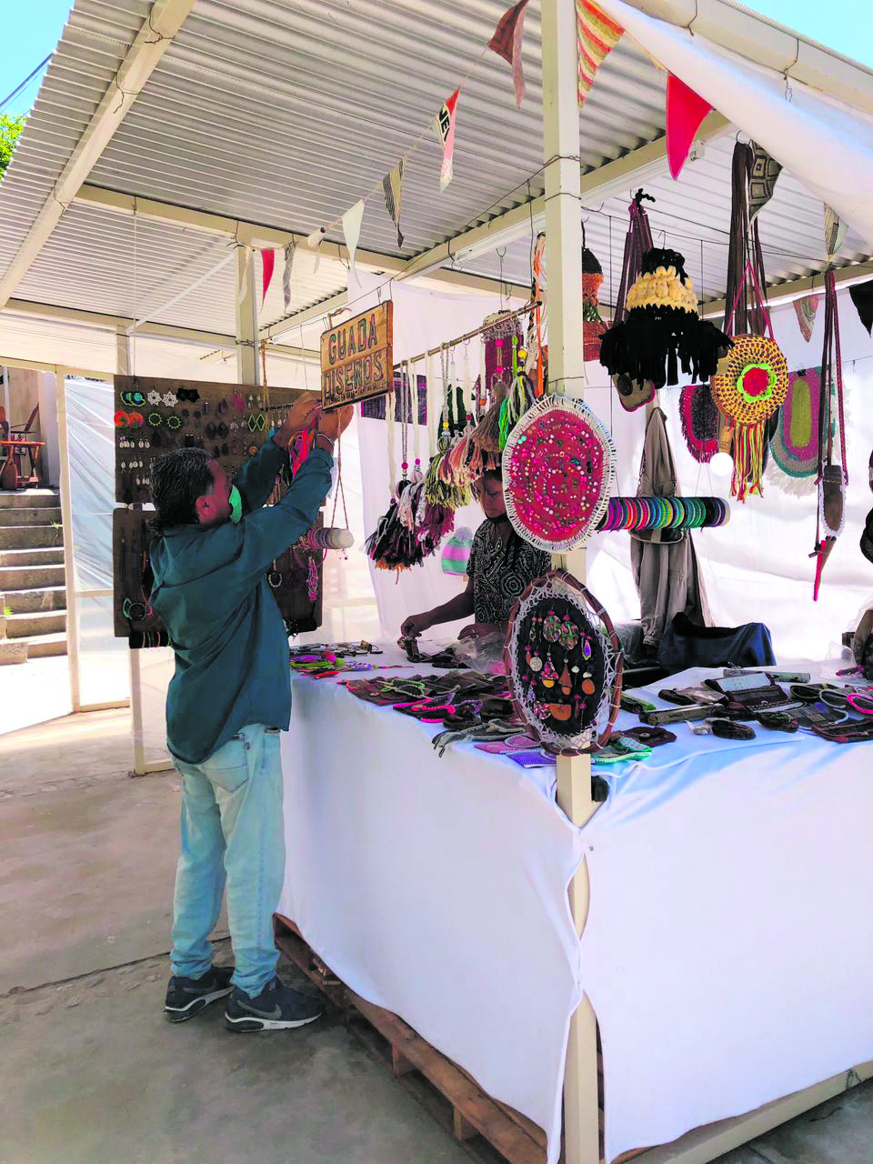 HECHOS A MANO. Uno de los artesanos prepara su puesto en la plaza principal de la villa.  