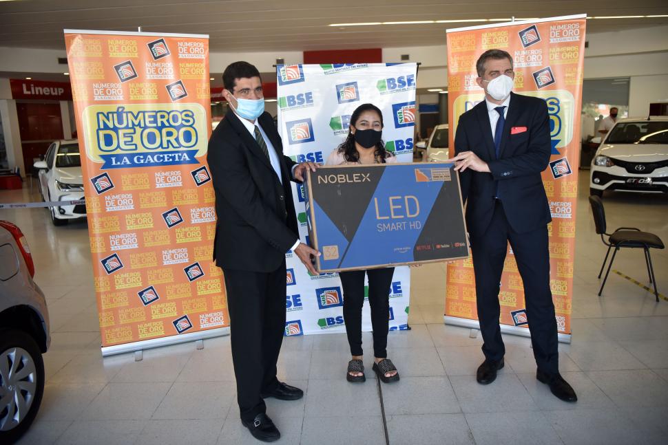 DIVERSIÓN HOGAREÑA. La ganadora recibió un smart TV de Juan Pablo del Pino (de Tarjeta Sol) y Gustavo Neme (del Banco Santiago del Estero). la gaceta / foto de inés quinteros orio