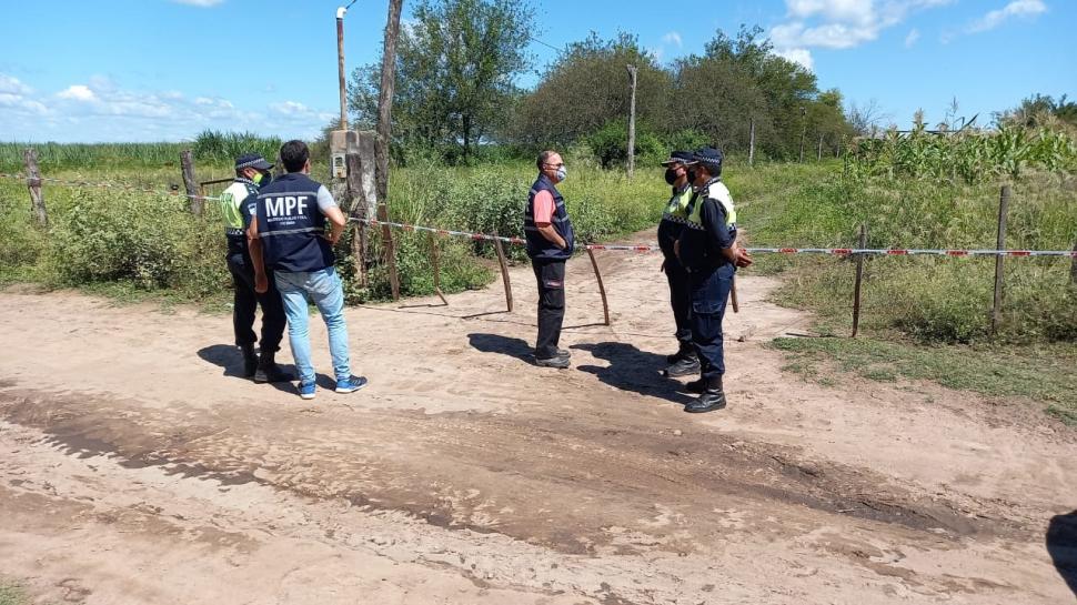 ESPERA. Los investigadores en la puerta del campo donde fue el hecho.