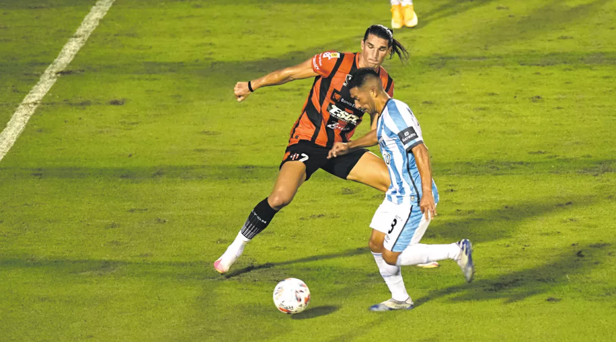 APORTE. Arriba, “Bebé” Acosta intenta desmarcarse de Gissi, en el primer tiempo.  A la derecha, Monzón se lleva la pelota pese al agarrón del visitante.