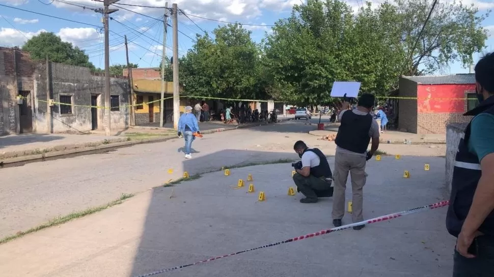 LAS PRUEBAS. Los peritos recogen los casquillos de balas que quedaron en la calle después de un tiroteo.  