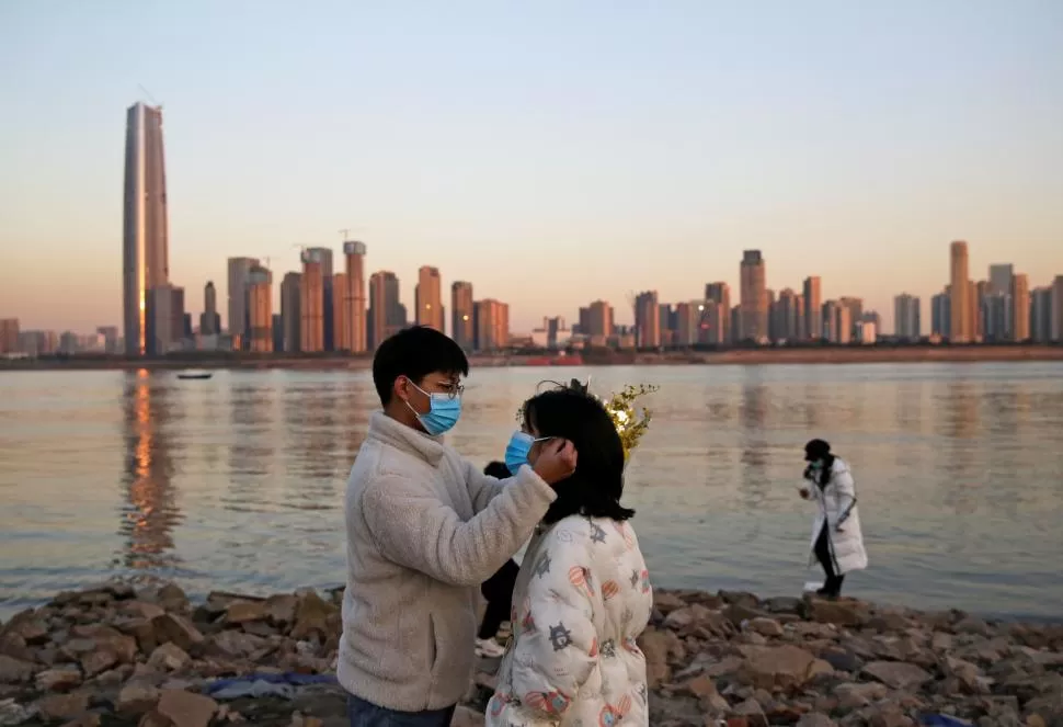 DONDE TODO COMENZÓ. La postal de fondo es de Wuhan, la ciudad china en la que el coronavirus hizo pie para expandirse luego con forma de pandemia. 