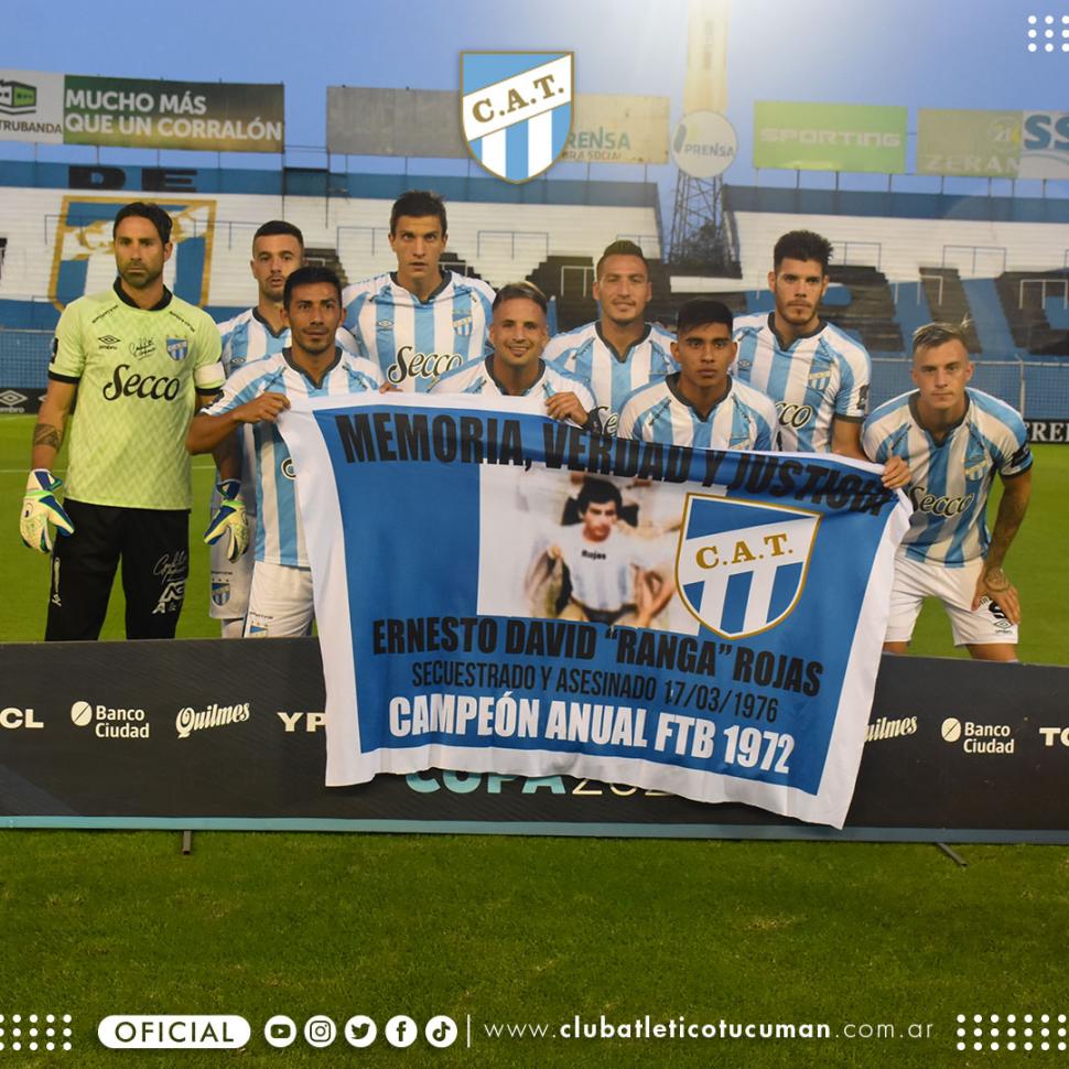 RECUERDO. Los jugadores posan con el cartel recordando a Ernesto Rojas, secuentrado y asesinado el  17 de marzo de 1976, por el terrorismo de Estado.