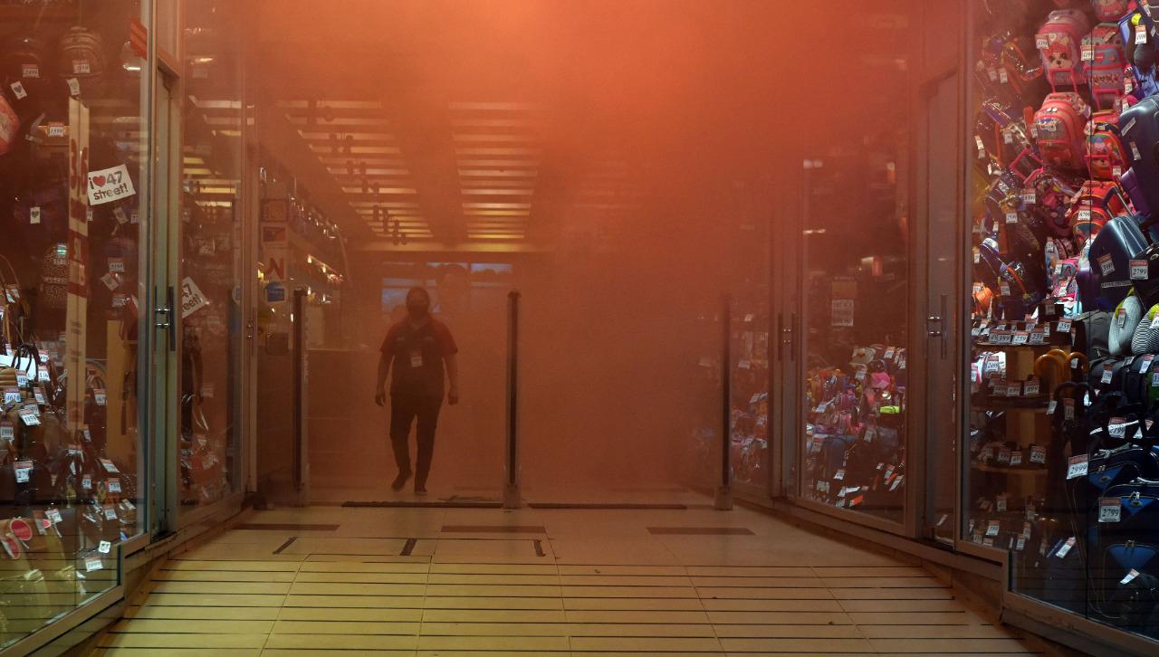 PROTESTA. El humo de bombas de arrojaron militantes del SEOC hizo que los clientes dejaran los comercios.