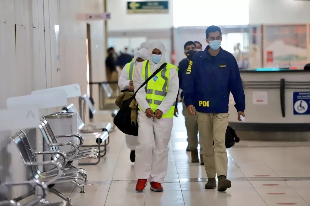  Los migrantes venezolanos fueron escoltados por las autoridades para abordar el avión que los lleva a Venezuela. Foto tomada de Twitter/@Gore_Tarapaca