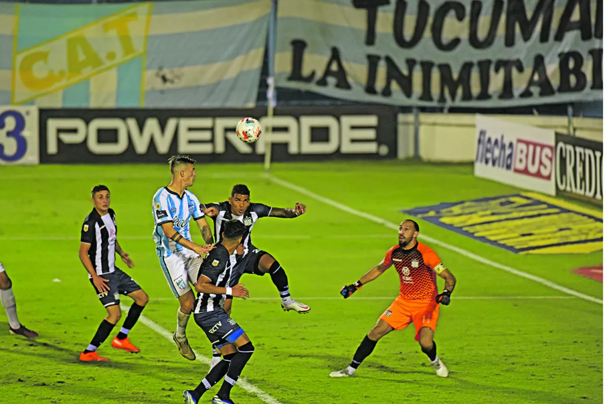 EN LO ALTO. Lotti cabecea la pelota, pese a la marca de los defensores “tallarines”. Javier Toledo contempla la escena, mientras que Marcos Díaz se apresta a intervenir.