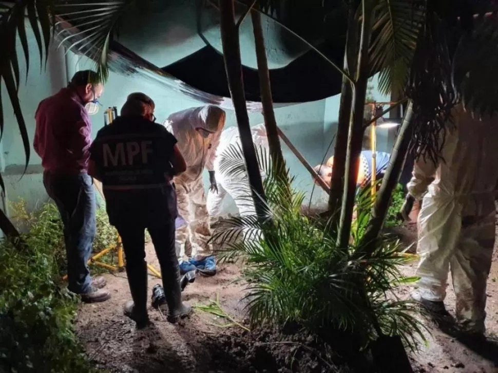 MOMENTO CLAVE. Peritos analizan el patio de una casa donde fue enterrado el cuerpo de la víctima.  