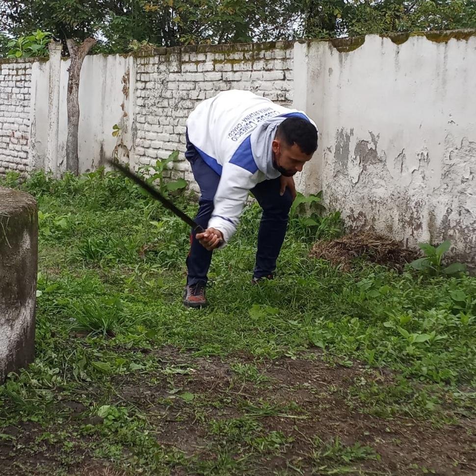 OFICIO. Franco, en plena tarea de desmalezamiento en el predio de una escuela.  