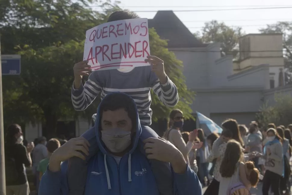 CON CARTELES. Un padre participa con su hija en la protesta.  