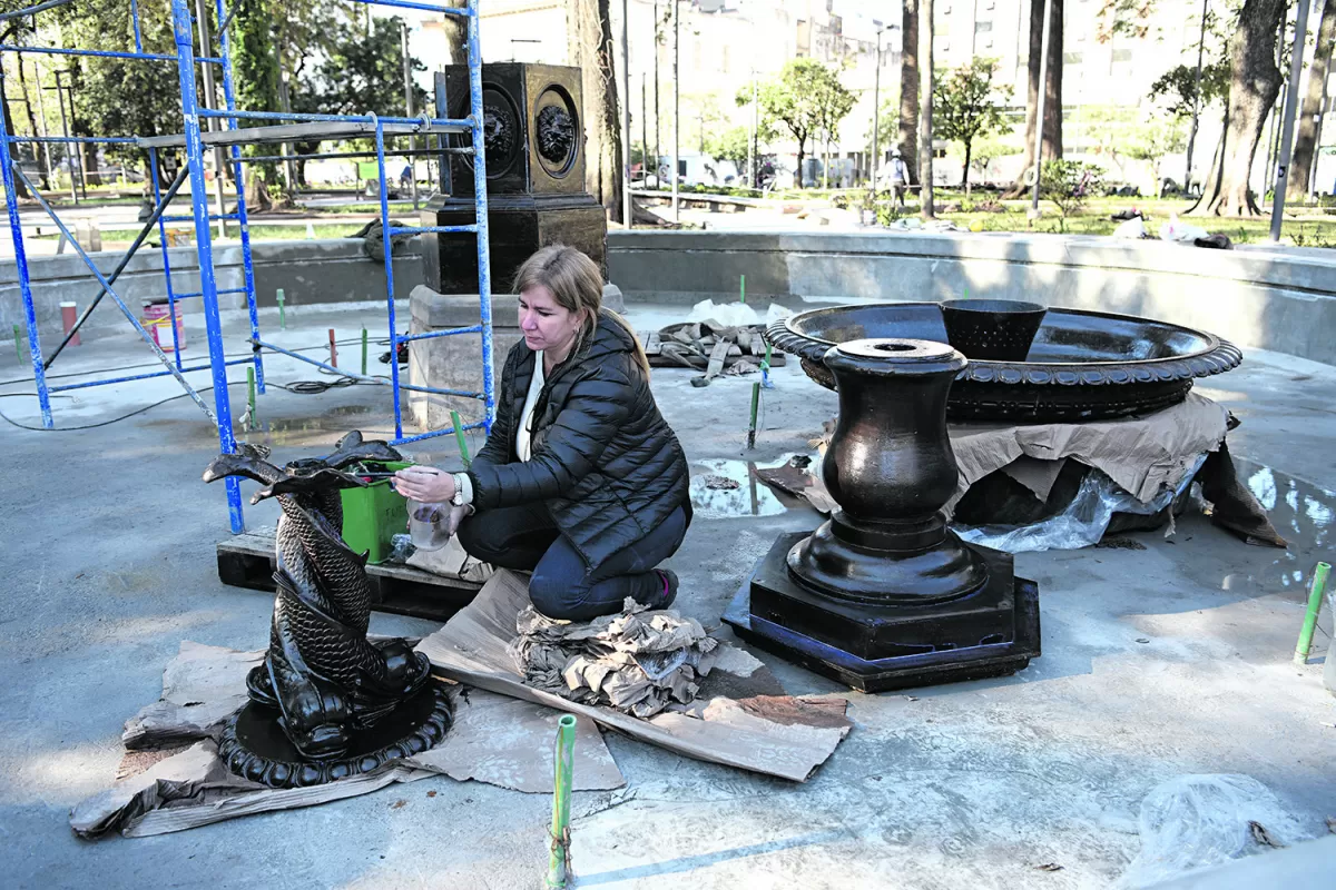 EN ACCIÓN. La restauradora María Eugenia Fagalde trabaja en un detalle de los tres delfines entrelazados que forman parte de la fuente de nuestro principal paseo público.