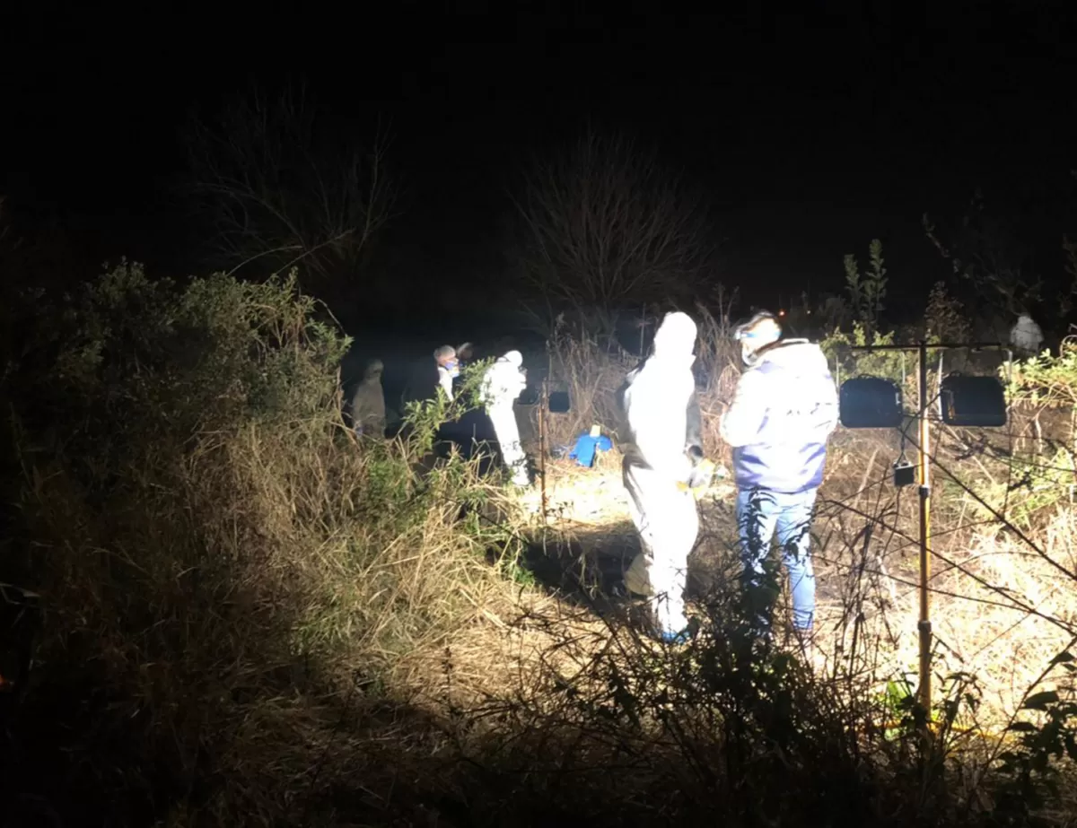 SIN PAUSA. Ya de noche, con la ayuda de luces, los peritos buscan pruebas en un pozo