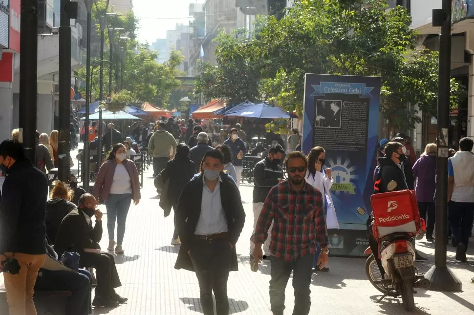 TAPABOCAS. Un solo hombre camina sin barbijo rodeado de ciudadanos que eligen usar tapabocas para cuidarse del coronavirus. 