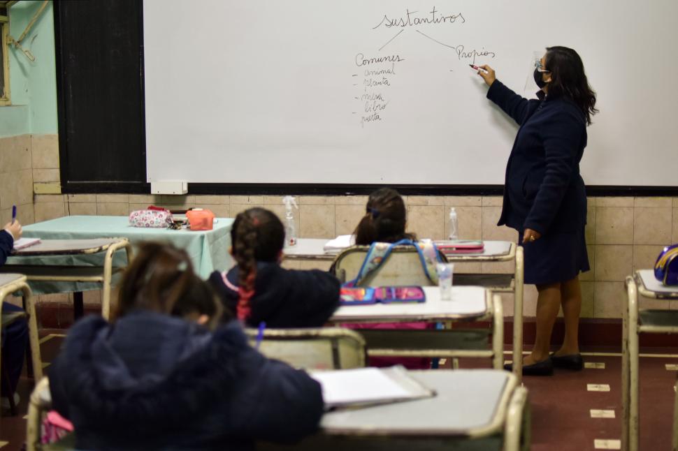 DISTANCIA. Maestra da clases a niñas que miran distanciados entre sí. 