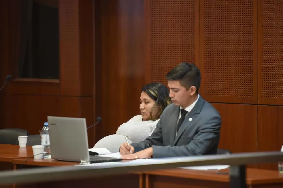 NO DABA MÁS. La acusada Jesica Osores se acomoda como puede en un momento de la audiencia junto a su abogado Aníbal Paz. 