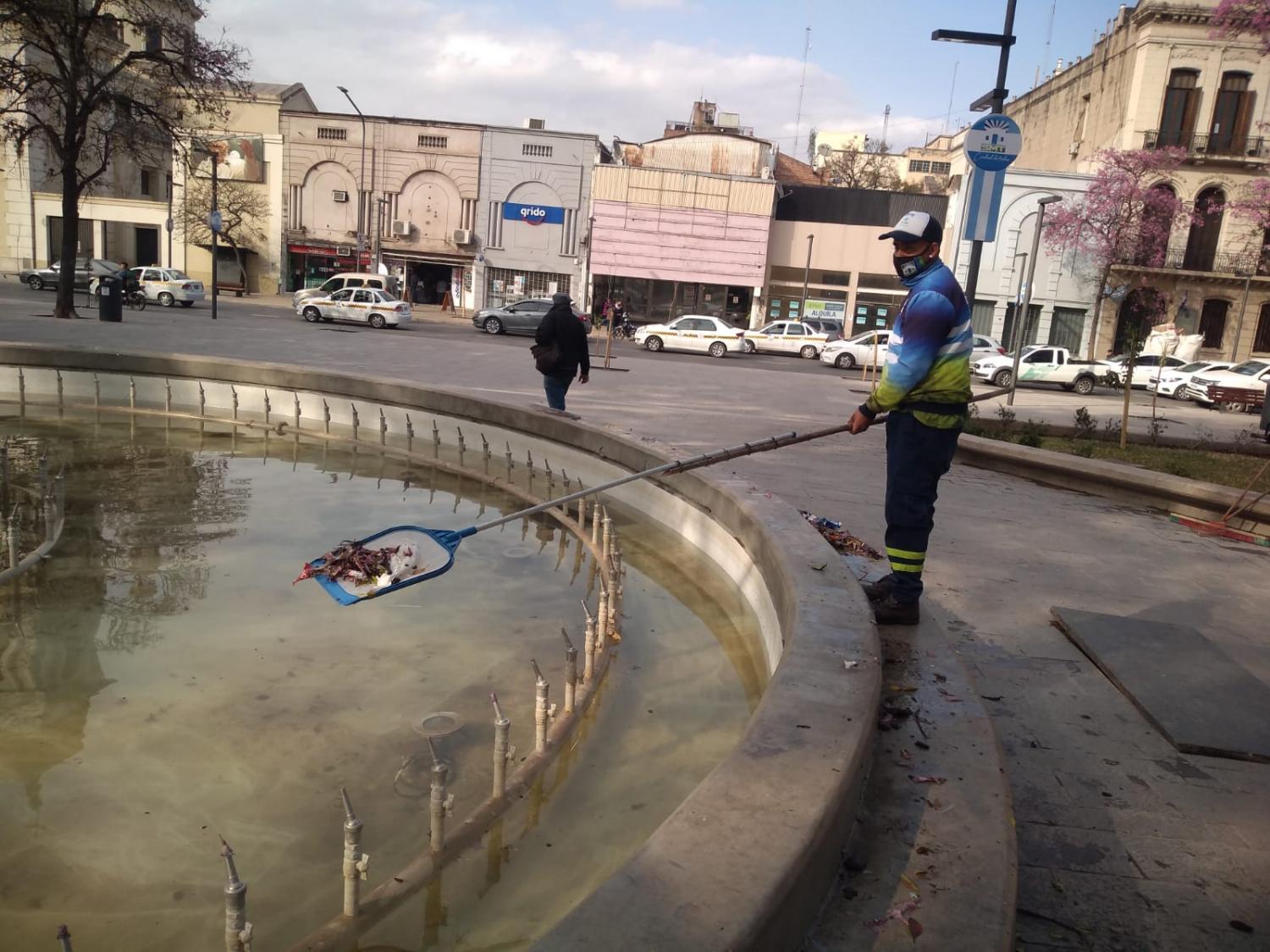 LIMPIEZA. Un empleado municipal retira un importante número de residuos de la fuente de la plaza.