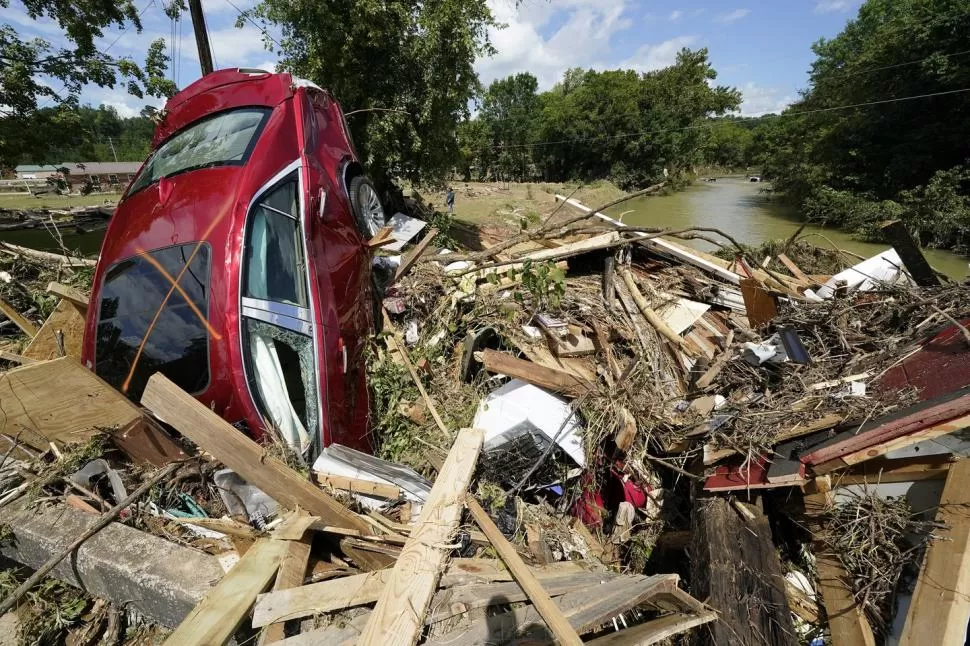FUERZA. El agua se llevó construcciones y arrastró autos hasta el río.   
