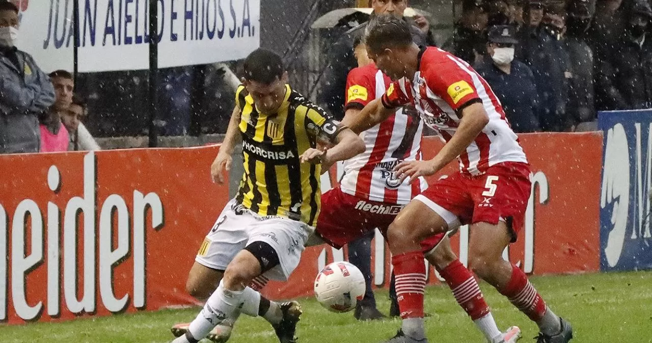 PELEADO. Rodrigo Herrera intenta frenar a Diego García en un partido áspero jugado hoy en Isidro Casanova. FOTO TOMADA DE TWITTER.COM/CLUB_ALTEBROWN