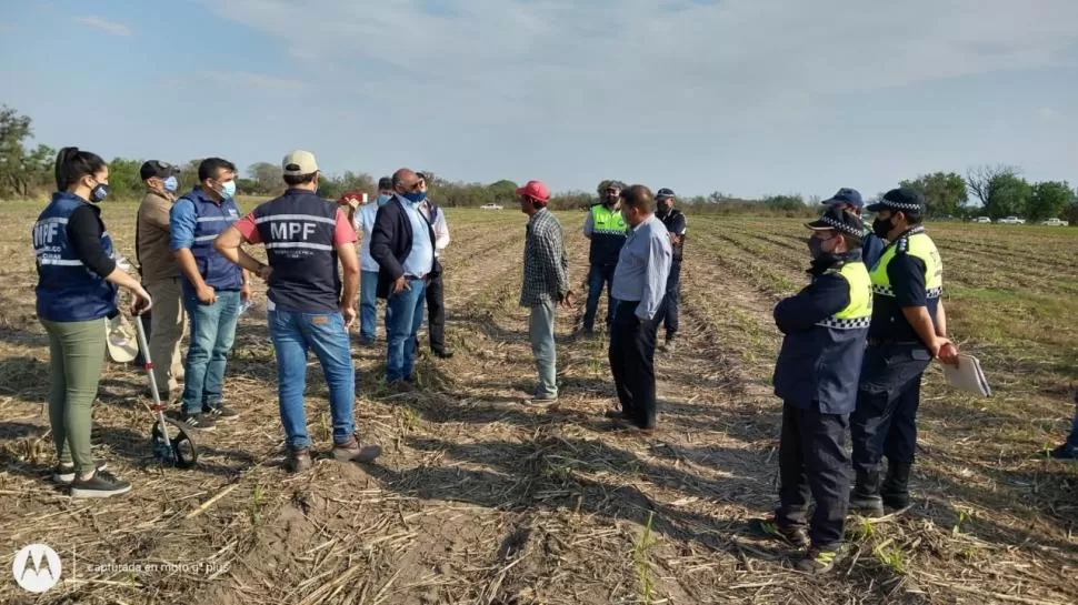 EN EL LUGAR DEL HALLAZGO. El fiscal Carlos Sale aparece rodeado por investigadores y peritos, mientras conversa con un vecino de la zona. 