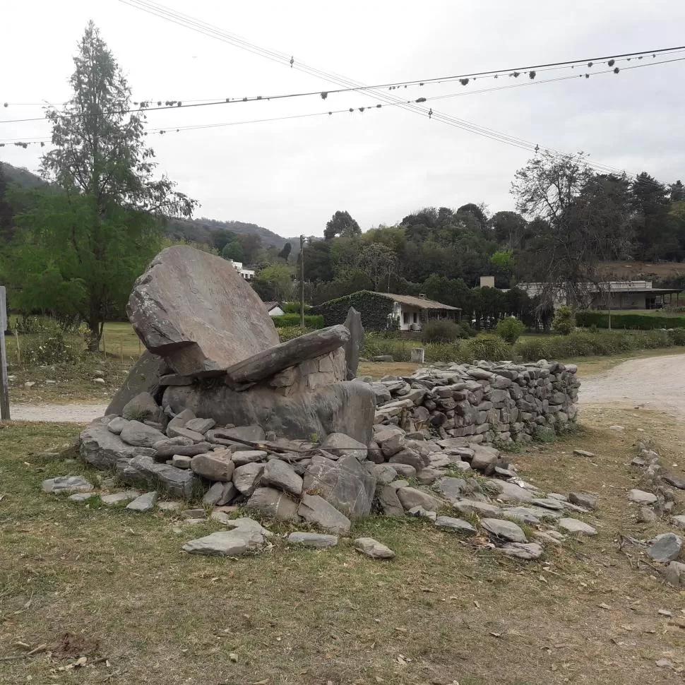 EN RACO. Arriba los restos recientes de un asado en uno de los laterales del monumento. Abajo, un solitario cartel de una zamba da aún nombre a una calle del pueblo. 