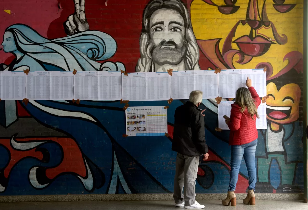 EN ALDERETES. Votantes revisan los padrones para chequear la mesa que se les asginó.