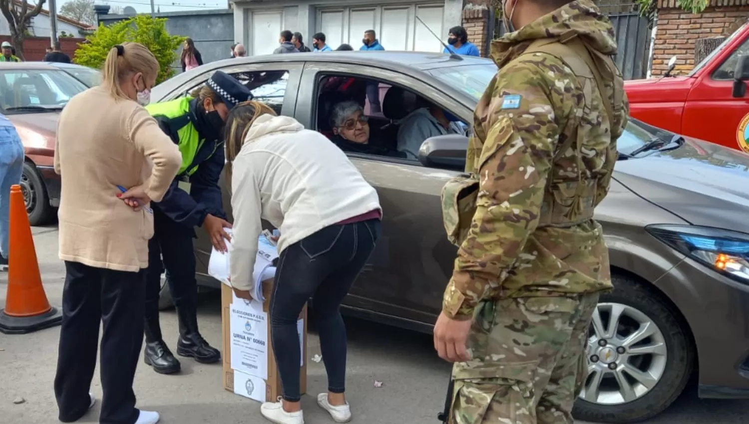 EN LA VEREDA. La mujer apenas salió del auto para poder sufragar.