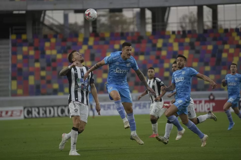 HIZO LO QUE PUDO. Ramiro Carrera fue el jugador del “Decano” que más buscó en el ataque. En la escena, trata de ganar de cabeza la pelota, ante la marca de un rival. Ruiz Rodríguez acompaña la acción. 