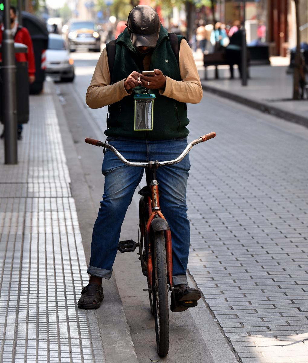 CORRECTA ACTITUD. El ciclista se detuvo junto al cordón para utilizar su celular. 