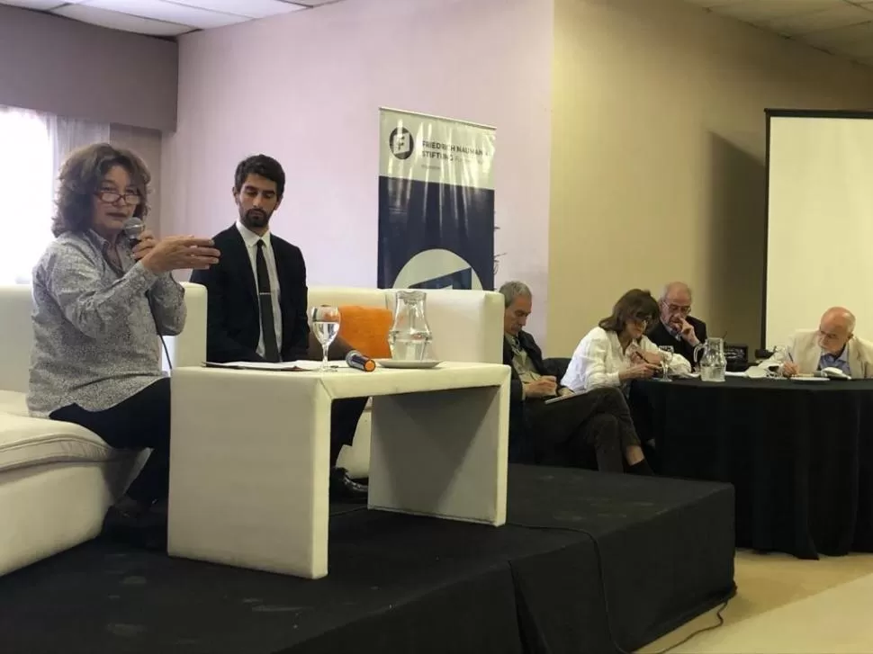 EN EL ESPACIO TAFÍ DEL HOTEL LUNAHUANA. Mustapic diserta: a su lado, el moderador Falcone y los colegas. 
