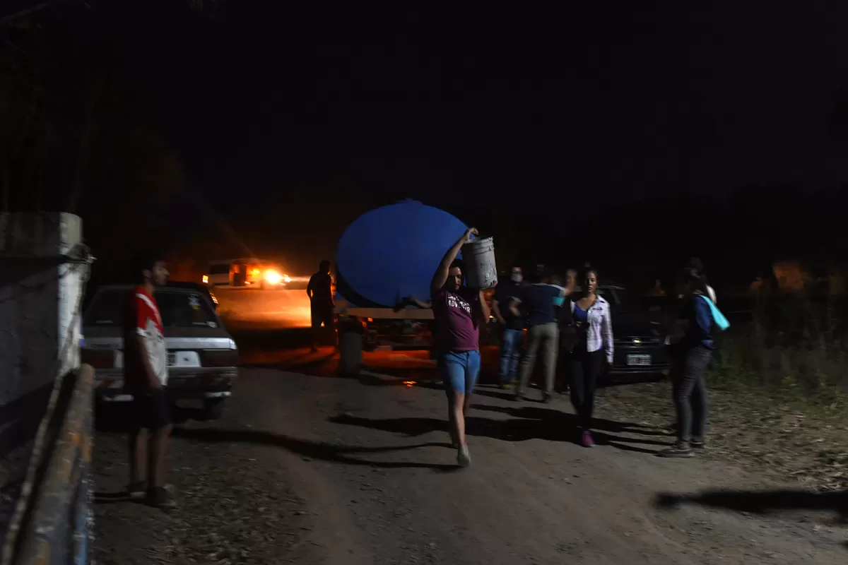 Esfuerzo conjunto: los vecinos de  la comuna ayudan a apagar los pequeños focos de fuego que quedaban a la noche.