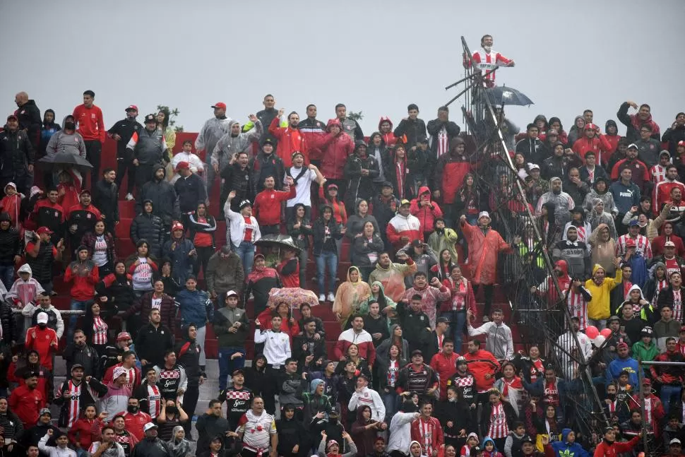 CÁNTICOS Y FESTEJOS. En las tribunas los hinchas aguantaron la lluvia y una temperatura que exigía abrigarse, quizás, con ropa de invierno. Entre paraguas, pilotines y bolsas plásticas los hinchas se cubrieron.  