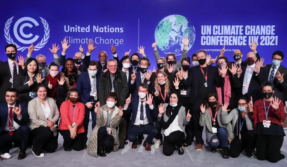 ROSTROS DISTENDIDOS. Una parte de los asistentes a la Cumbre Climática de Glasgow saludan tras concluir las arduas negociaciones. reuters