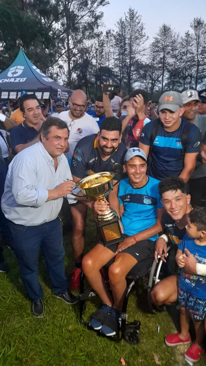 CON LA COPA. José “Chuchú” Basile, esbozando una gran sonrisa, recibe la Copa de Oro junto al capitán Emanuel Albarracín. Gentileza foto de Adrián Coronel