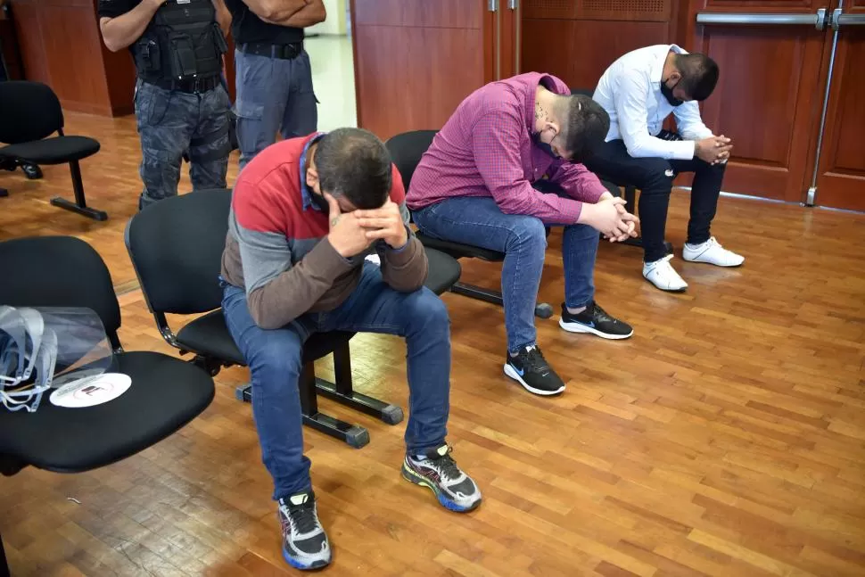 ESQUIVAN LAS CÁMARAS. Tres de los acusados agachan la cabeza y se cubren el rostro para no figurar en las fotos. Ayer declararon sus testigos.  