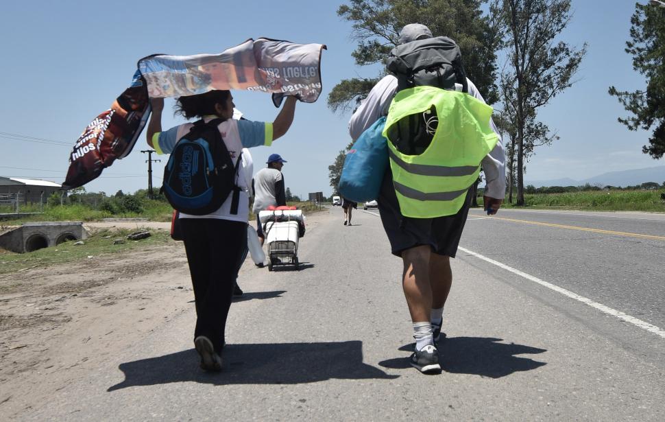 CARGADOS Y CON FE. Llevan mochilas con todo para acampar.