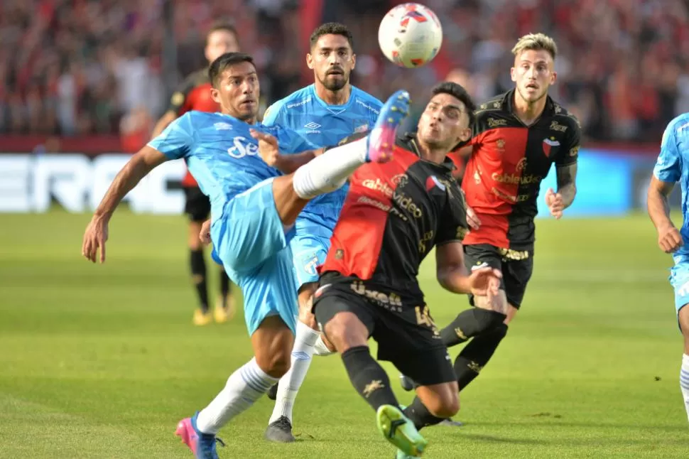 FIRMEZA. Acosta disputa la pelota con Farías, “Bebé” volvió al equipo titular, pero no le dio equilibrio a la mitad de cancha.  