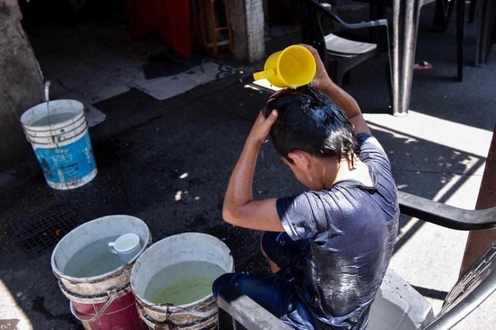 UNA DUCHA DE BALDE. Un niño aprovecha la poca agua recogida para mojarse la cabeza, en un jornada de temperaturas agobiantes. la gaceta / foto de inés quinteros orio