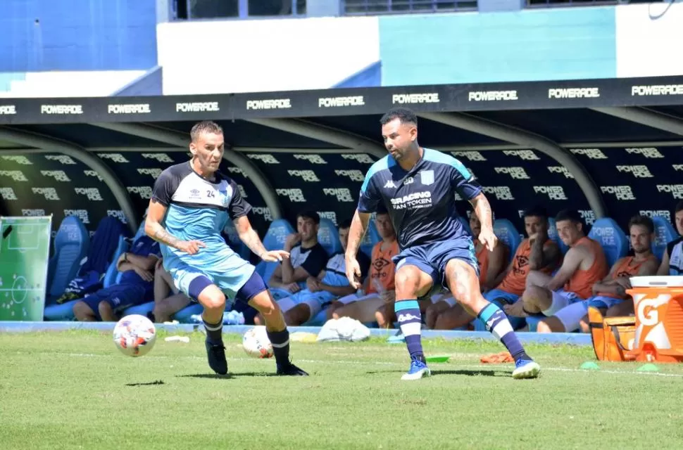 INTENSO. El segundo partido entre Racing y Atlético se jugó con dientes apretados. Tesuri y Cardona disputan la pelota ante la atenta mirada de los futbolistas “decanos” que jugaron el primer amistoso. twitter @RacingClub