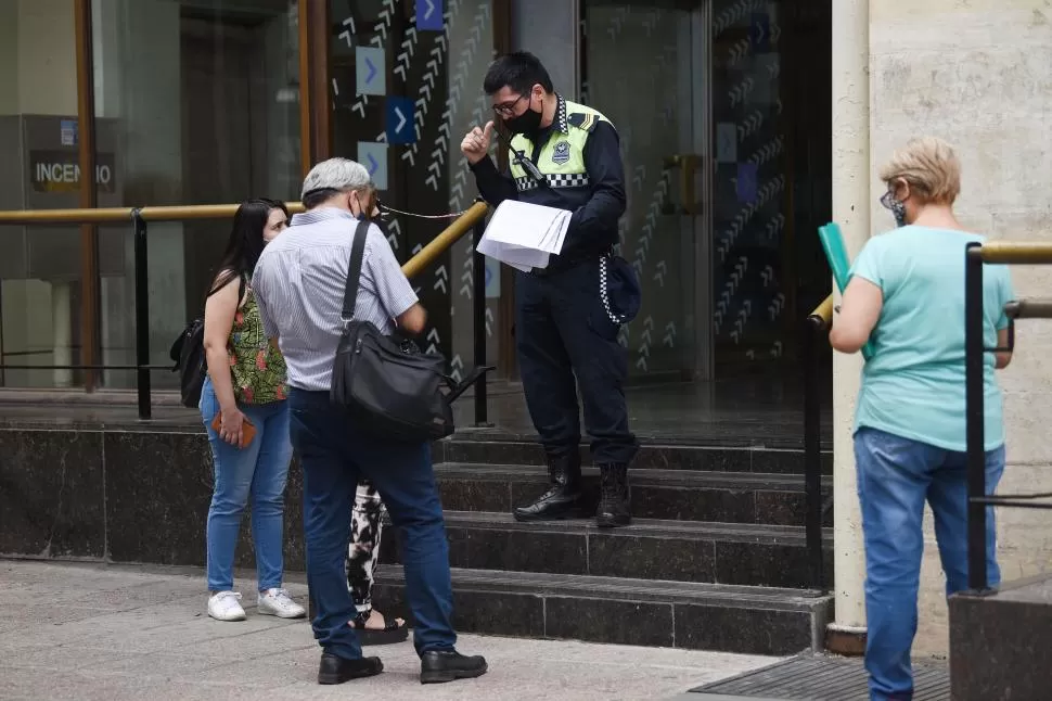 EN LA FILA. Algunas personas se acercan a uno de los accesos al banco Nación para consultar sobre sus trámites. Se habilitaron opciones digitales.  