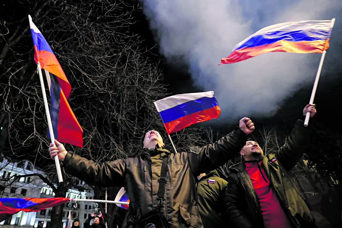 ALGARABÍA. Activistas prorrusos festejan, luego de que el presidente Vladimir Putin firmó un decreto que reconoce a dos regiones separatistas.