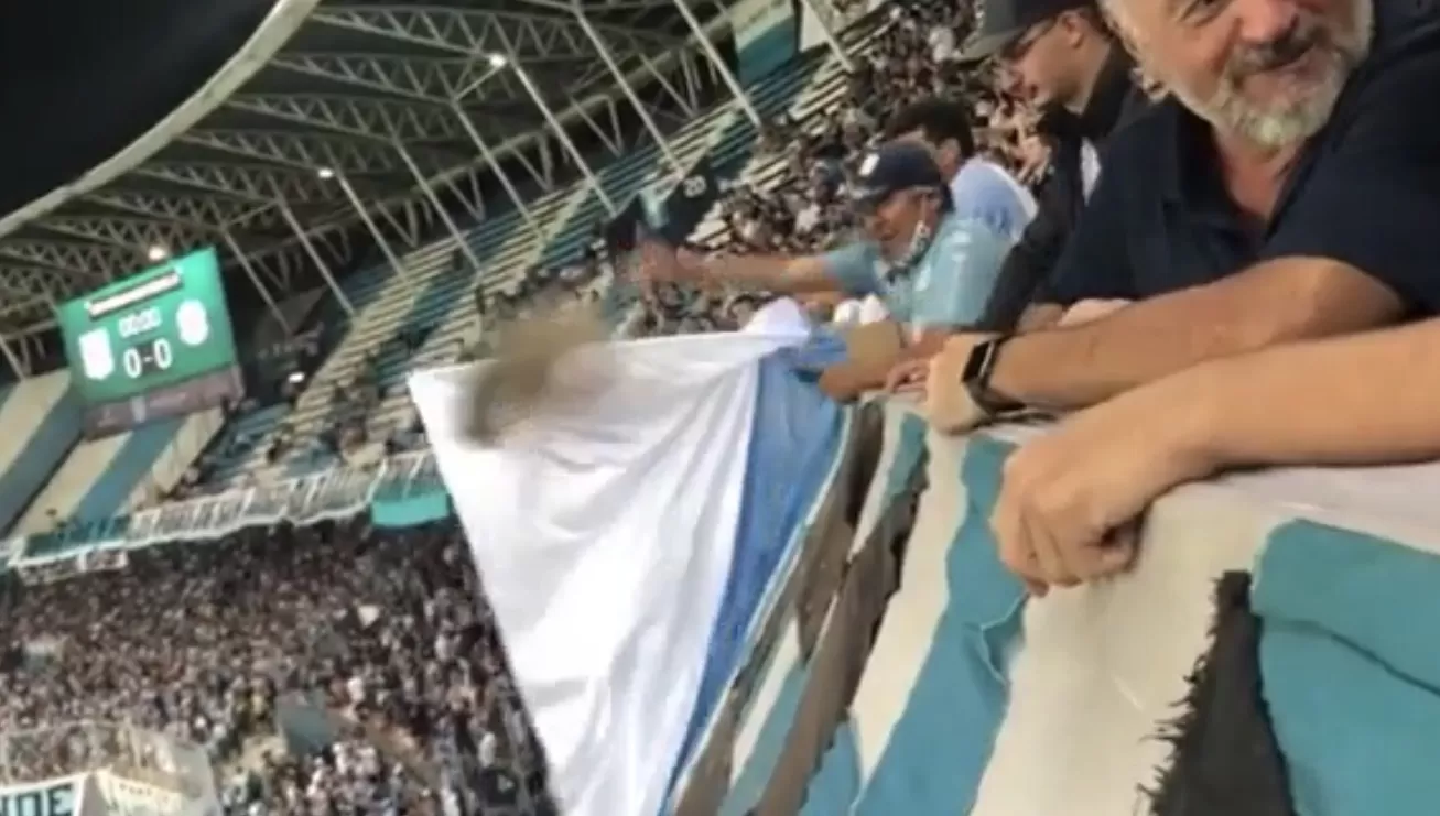 HOMENAJE. El momento en que una persona arroja sobre la cancha las cenizas de un ser querido fallecido, fanático de Racing.