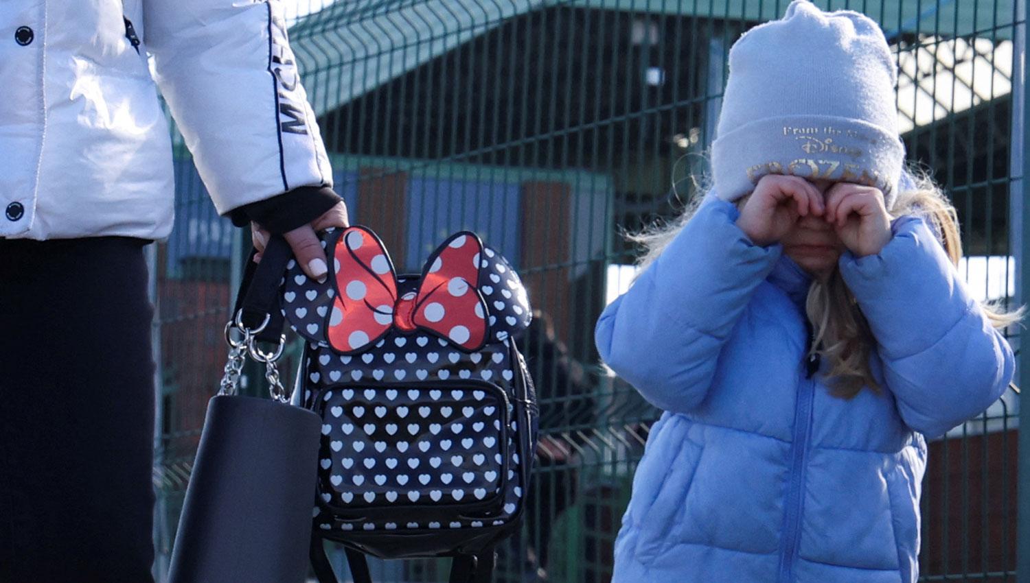 A POLONIA. Una niña junto a su madre caminan hacia el puesto fronterizo de Medyka, en Polonia.