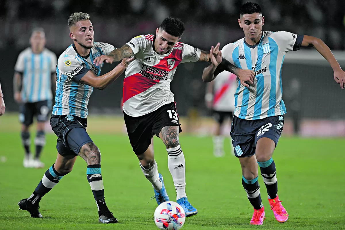 MARCA A PRESIÓN. Enzo Fernández, de buen nivel, se lleva la pelota ante el asedio de dos jugadores de la “Academia”.