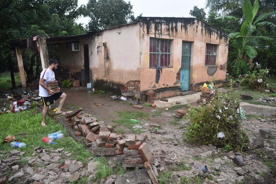 EL MANANTIAL. Andrés Bazán recoge los ladrillos de las paredes que la inundación destrozó.