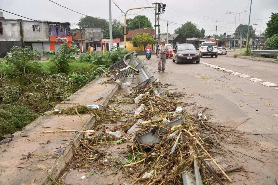 CANAL SUR. En el puente de avenida Independencia la crecida que arrastró ramas y basura, desmoronó la contención del canal y rompió la baranda y el guardarraíl de la calle. LA GACETA  